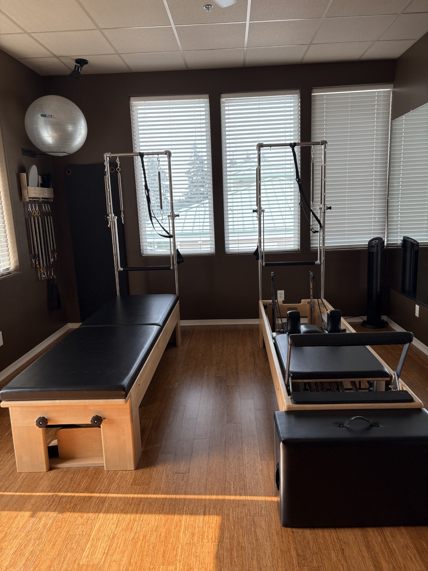 Inside the SLOW burn studio — reformer and tower with natural window light